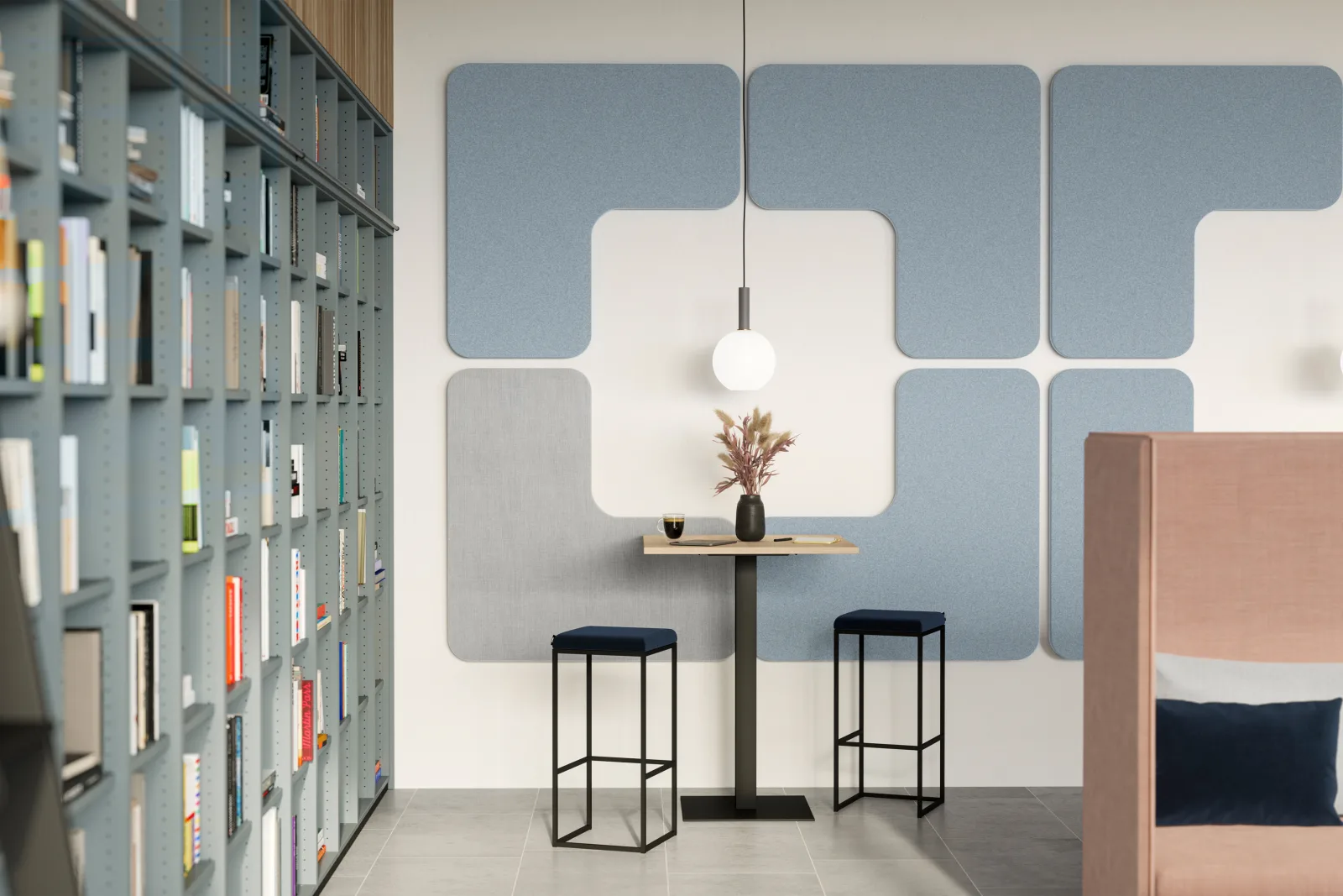 Stehtisch mit zwei Hockern vor einer Wand aus blauen und weißen Akustikelementen, daneben ein hohes Regal