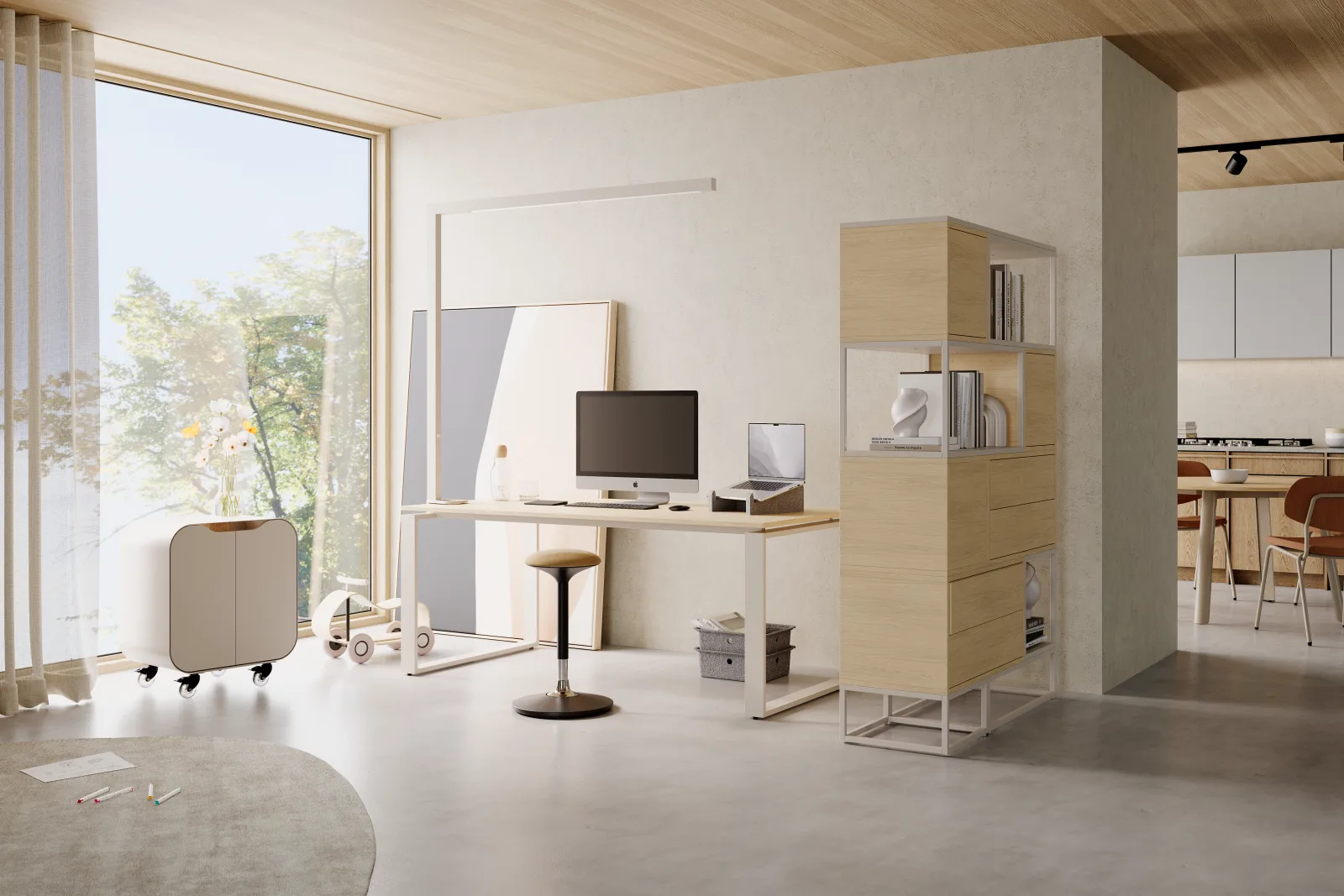 Schreibtisch mit Monitor und Sitzhocker vor einer bodentiefen Fensterfront, dahinter der offene Wohnbereich