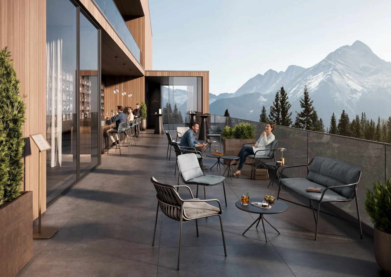 Dachterrasse eines Hotels mit Loungesesseln und kleinen Tischen, dahinter eine verglaste Bar